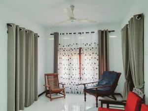 a living room with two chairs and a window at Rustic Villa 7 in Weligama