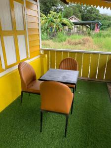 two chairs and a table on a screened in porch at Arau Heritage Home in Arau