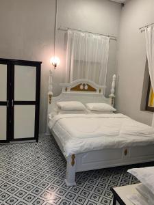 a bedroom with a large white bed in a room at Arau Heritage Home in Arau