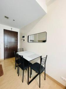 une salle à manger avec une table et des chaises noires dans l'établissement 20 Pool View Studio Bliss, à Cari Mayor