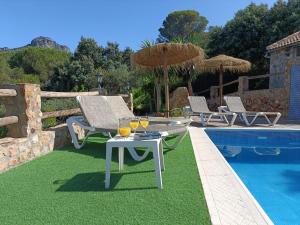 a table with wine glasses on it next to a pool at Villa Jael in El Gastor