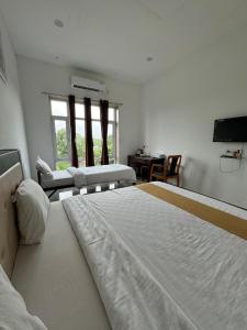 KevadiaVasant Vihar Resort的一间卧室，配有两张床、一张书桌和一台电视