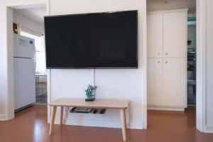 einen Flachbild-TV an einer Wand im Wohnzimmer in der Unterkunft Cali 2BR Getaway Firepit, Yard & Spring Charm in Tucson