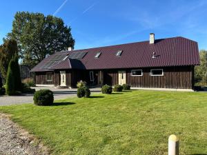 a large wooden house with solar panels on it at Kiisa Jahi- ja Matkamaja in Holvandi