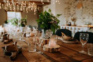 a long wooden table with wine glasses and flowers at Kiisa Jahi- ja Matkamaja in Holvandi