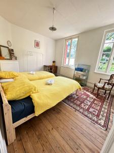 a bedroom with a large bed with a yellow blanket at La Petite Escapade - Maison de pêcheur traditionnelle - Centre-ville in Fécamp