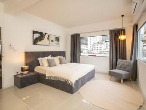 a bedroom with a large bed and a chair at 2-Bedroom Penthouse in the heart of Silom - 4A in Bang Rak