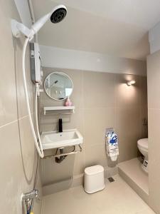 a bathroom with a sink and a mirror and a toilet at Nap by Snooze in Bangkok
