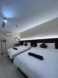 瓜拉江沙Kangsar KK Hotel的酒店房间里有两张床，铺着白色床单