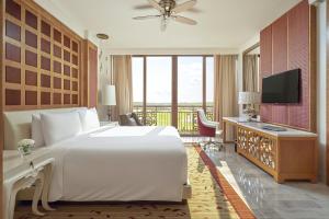 a bedroom with a large white bed and a television at InterContinental Grand Ho Tram in Ho Tram