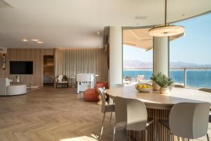 a dining room and living room with a table and chairs at Queen Anne - Penthouse apartment with private pool in Eilat