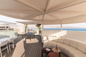 a balcony on a yacht with a couch and tables at Queen Anne - Penthouse apartment with private pool in Eilat
