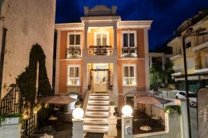 a building with a staircase leading up to it with umbrellas at Andromeda Boutique Hotel in Kastoria