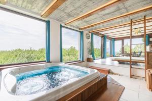 una grande vasca da bagno in una stanza con una grande finestra di Podhamer Wellness Vineyard Cottages a Ljutomer