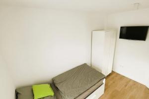 a small room with a bed and a tv at 85qm Neubau-Wohnung für 5-6 Personen, 2 Badezimmer & 3 Schlafzimmer in Hörstel