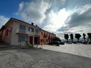 a building with cars parked in a parking lot at L'INCANTO CASA VACANZE in Montegrosso dʼAsti