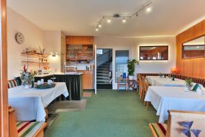 a restaurant with white tables and chairs and a staircase at Pension Talblick Bad Grund in Bad Grund