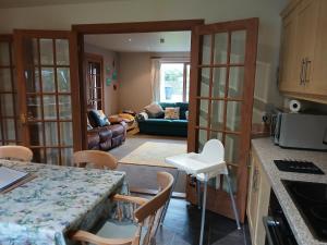 a kitchen and living room with a table and chairs at Holiday House Kinveachy in Aviemore