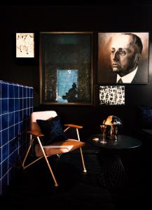a room with a chair and a table and a picture at Libertine Lindenberg in Frankfurt/Main