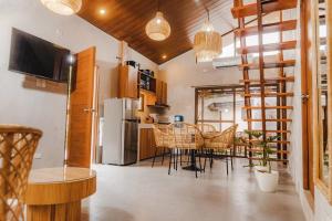 a kitchen with a table and chairs and a refrigerator at Villa Adara by Araw Residences in Luksuhin