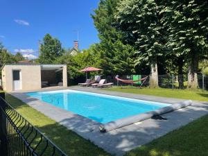 a swimming pool in the backyard of a house at Le charme d'othe in Bellechaume