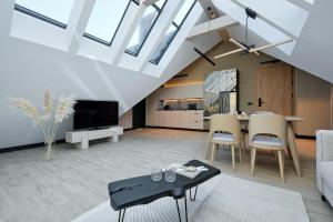 ビャウカにあるRezydencja Słoneczna - SPA & Apartamenty z widokiem - Białka Tatrzańskaのテーブルと椅子のあるリビングルーム