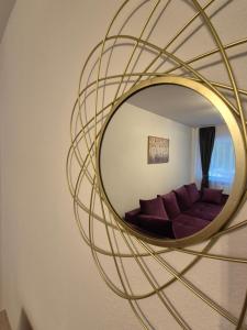 - un miroir circulaire dans le salon avec canapé dans l'établissement Family Residence Slănic-Moldova, à Slănic-Moldova