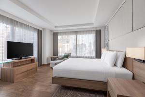 a hotel room with a bed and a tv at Courtyard by Marriott Bangkok in Bangkok