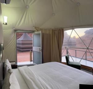 a bedroom with a bed and a view of a tent at Moon rum 2 in Disah