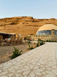 a patio with chairs and a building in the desert at Moon rum 2 in Disah
