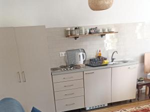 a kitchen with a sink and a counter top at Apartmani Jelenača in Sinanovići