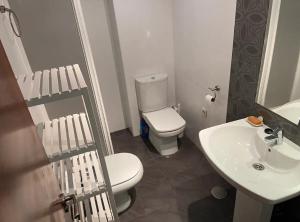 a bathroom with a white toilet and a sink at Sego Apartments III in Segovia +10 photos