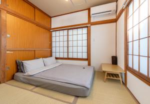 een slaapkamer met een bed in een kamer met ramen bij 吉房民宿 YOSHIFUSA House 晴空塔徒步圈 整栋出租 in Tokyo