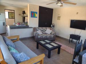 a living room with a couch and a table at Beautilful ocean views from this apartment in Chelem