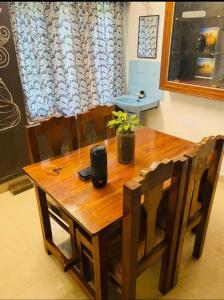 a dining room table with chairs and a wooden table with at The Varkala Retreat Villa in Varkala