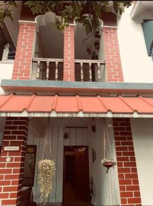 a building with a porch and a door with a balcony at The Varkala Retreat Villa in Varkala