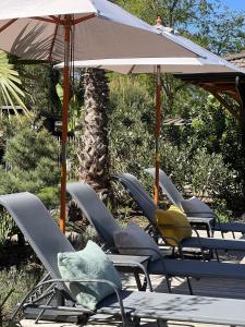 a group of lawn chairs and an umbrella at VillaCanau in Lacanau +31 photos