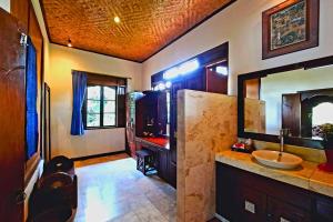 une grande salle de bain avec un lavabo et un miroir dans l'établissement Falguni 1 BR Grand Deluxe Garden View ZN241, à Ubud