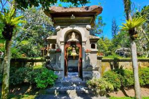 une porte vers une maison avec une fontaine dans l'établissement Falguni 1 BR Grand Deluxe Garden View ZN241, à Ubud