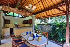 une cuisine et une salle à manger avec une table et des chaises dans l'établissement Falguni 1 BR Grand Deluxe Garden View ZN241, à Ubud