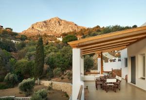a patio with a table and chairs and a mountain at Haroupia Hillside Villa in Kalymnos