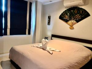 a bedroom with a bed with a white animal laying on it at Seaview Condominium A13 in Ban Tha Fat