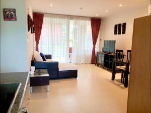 a living room with a blue couch and a television at Seaview Condominium A13 in Ban Tha Fat