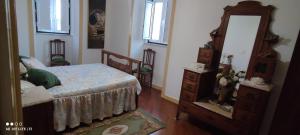 a bedroom with a bed and a dresser and a mirror at Casa de Penela in Penela