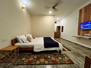 a bedroom with a bed and a flat screen tv at Grand Narmada Jungle Homestay Resort-Bandhavgarh in Tāla