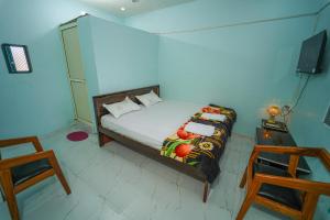 a bedroom with a bed and a tv and a chair at Hotel Ramlalla Palace in Ayodhya