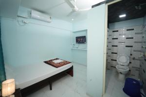 a white bathroom with a toilet and a sink at Hotel Ramlalla Palace in Ayodhya
