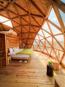 una stanza con un letto in una grande tenda di legno di Kuoom Serengeti a Robanda