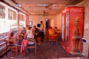 a group of people sitting at tables in a restaurant at Hotel Ramlalla Palace in Ayodhya