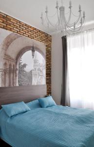 Schlafzimmer mit einem blauen Bett und einem großen Fenster in der Unterkunft White Dream Home in Budapest